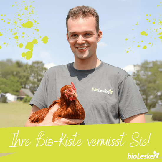 KI generiert: Ein Mann hält ein Huhn in den Armen und trägt ein T-Shirt mit dem Aufdruck "bioLesker". Im Bild steht der Text "Ihre Bio-Kiste vermisst Sie!" vor einem ländlichen Hintergrund.