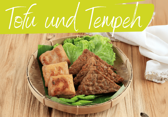 KI generiert: Das Bild zeigt einen Teller mit gebratenem Tofu, Tempeh und frischem Gemüse auf Salatblättern. Darüber steht der Schriftzug "Tofu und Tempeh".