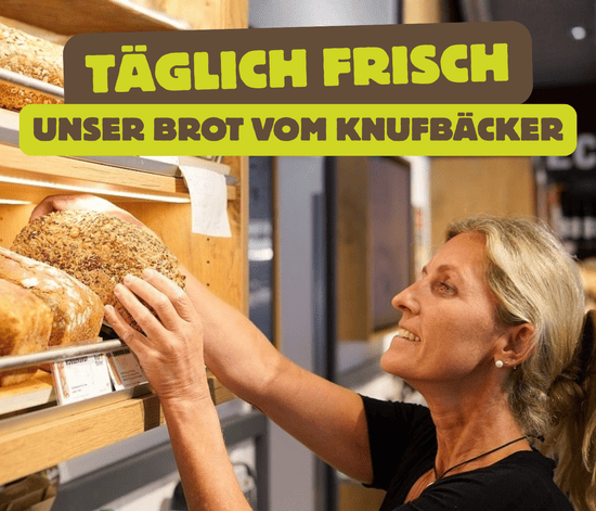 KI generiert: Ein Mann hält ein Huhn in den Armen und trägt ein T-Shirt mit dem Aufdruck "bioLesker". Im Bild steht der Text "Ihre Bio-Kiste vermisst Sie!" vor einem ländlichen Hintergrund.