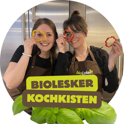 KI generiert: Das Bild zeigt einen frischen Wintersalat mit Feldsalat, Walnüssen, Cashewkernen und Kirschtomaten auf einem schwarzen Teller. Der Salat wirkt bunt und appetitlich.