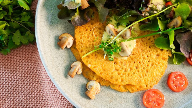 KI generiert: Das Bild zeigt eine herzhafte Tarte mit Kartoffelkruste, belegt mit roten Zwiebeln, Walnüssen und Kräutern. Rundherum sind rohe Kartoffeln, rote Zwiebeln und Walnüsse dekorativ arrangiert.