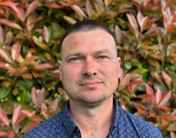 KI generiert: Ein Mann vor einer Wand aus bunten Blättern.